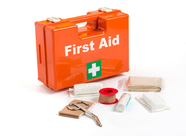 Bright orange first aid kit box with content laid out